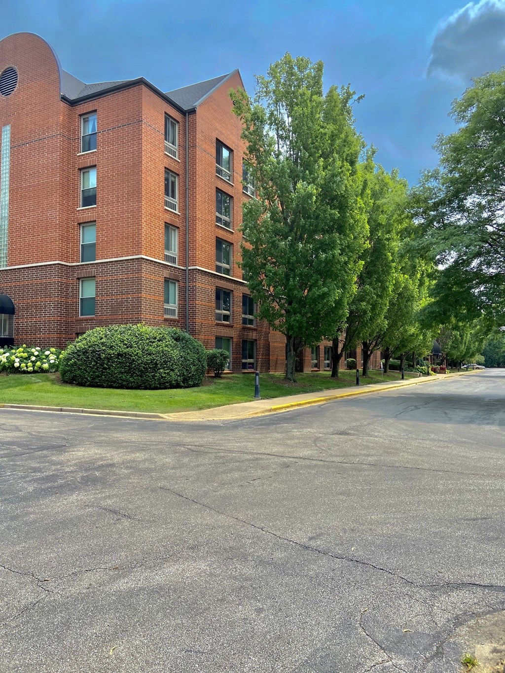 A red brick building with a green lawn in front.