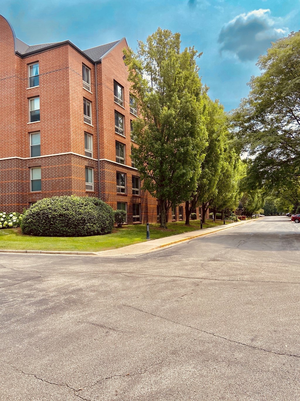 A red brick building with a green tree in front.