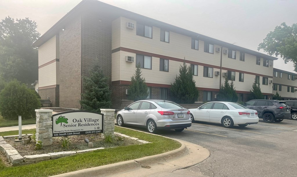 A building with a sign that says Oak Village Senior Residences.