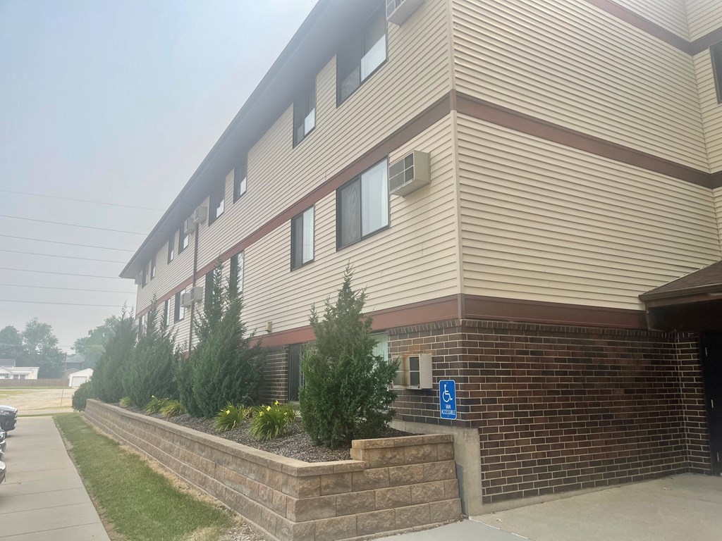 A building with a blue handicap sign on the wall.
