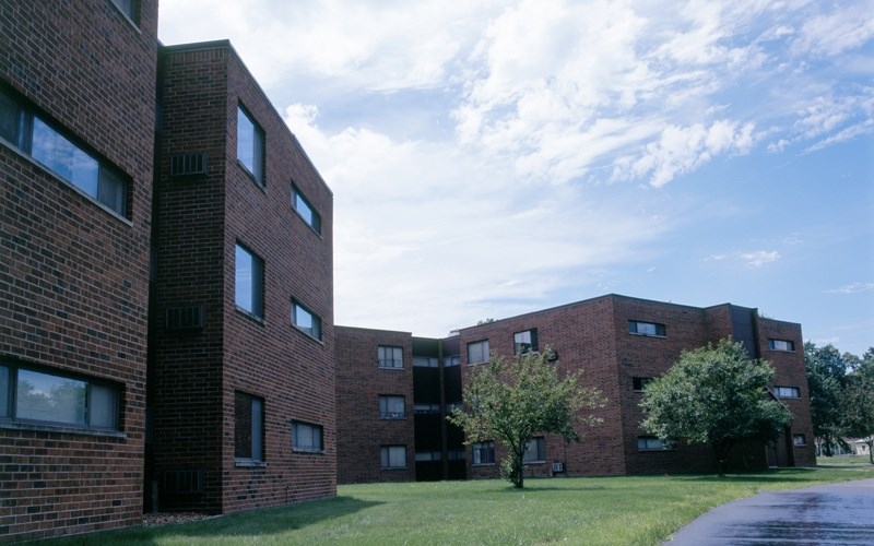 A large brick building with a tree in front of it.