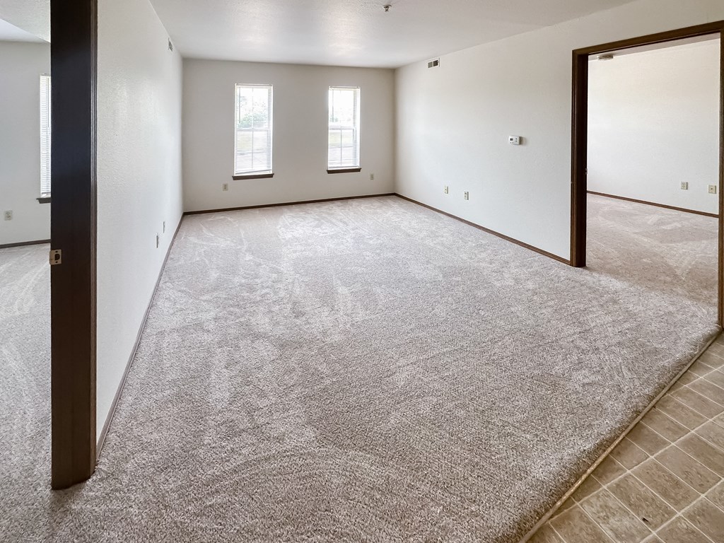 the living room of a new home with carpet and white walls