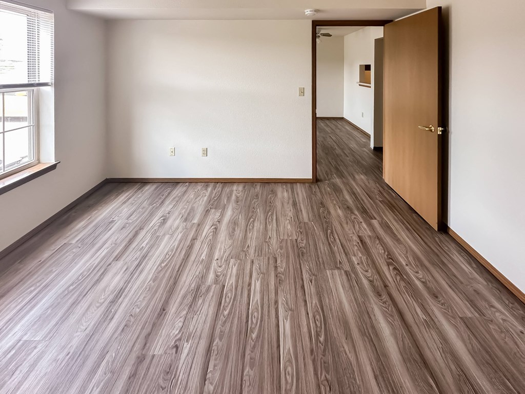 the living room and dining room in a new home with wood flooring