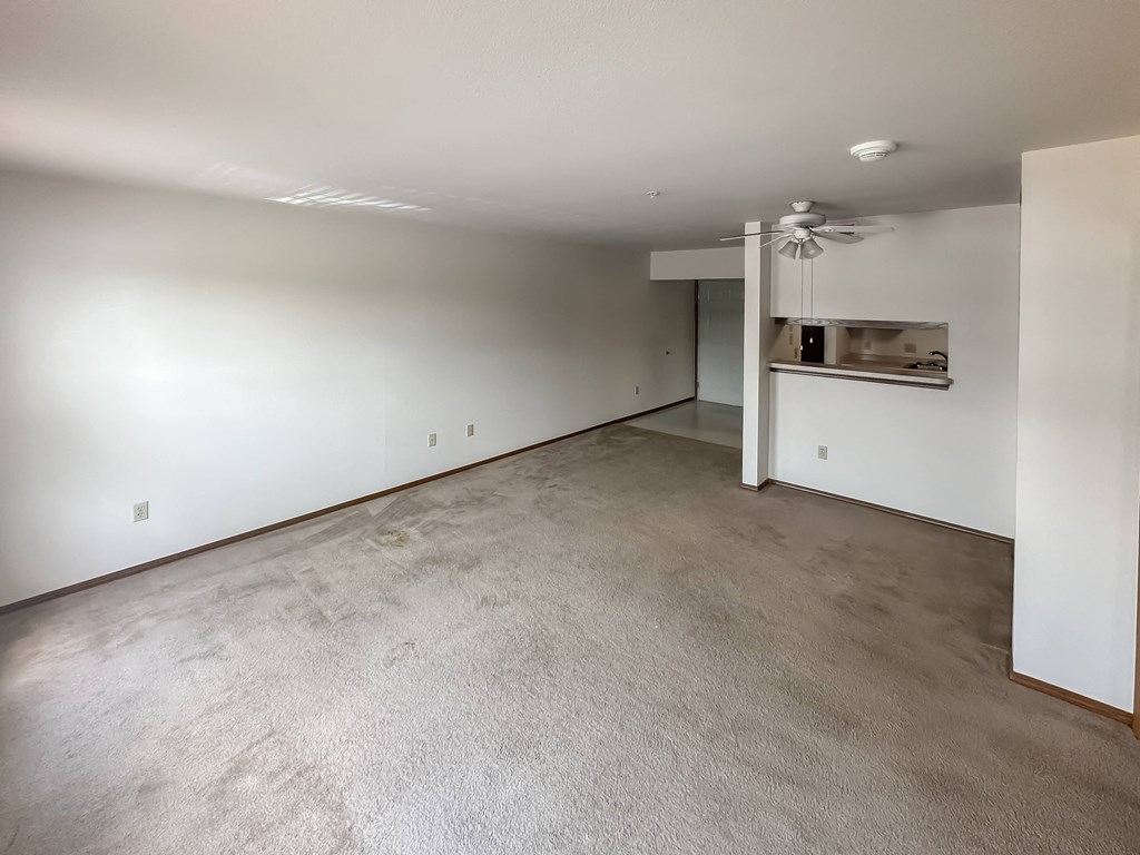 an empty living room with white walls and a concrete floor