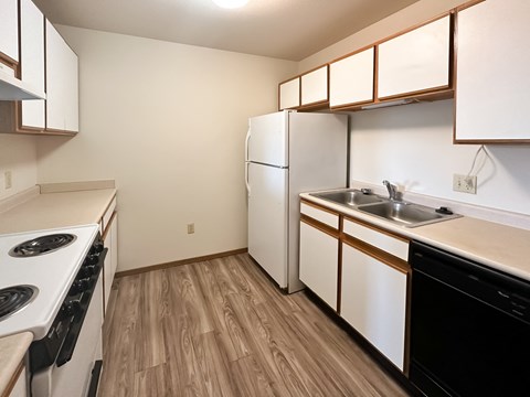 A kitchen with a white stove and a white refrigerator.