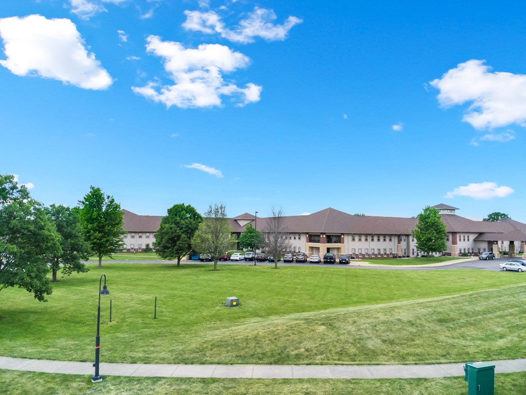 a large building with a grass field in front of it