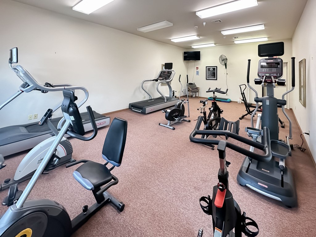 a gym with various exercise equipment on the floor