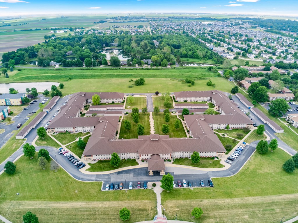 an aerial view of a parking lot with a large building in the middle