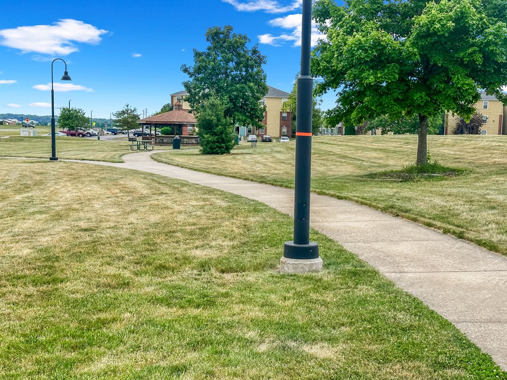 a walkway through a park on a sunny day