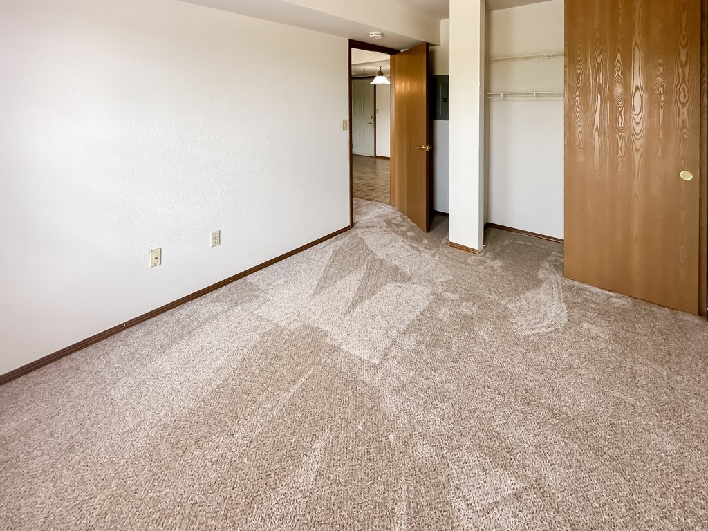 a living room and hallway with carpet and wood doors