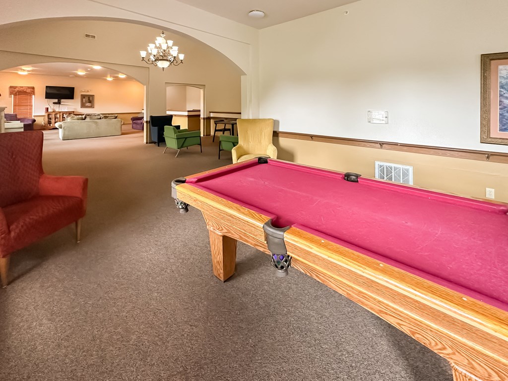 a game room with a pink pool table