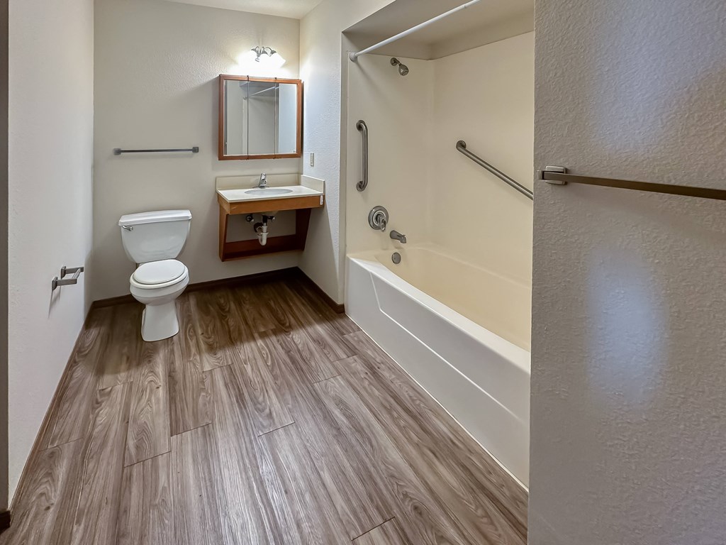 a bathroom with a toilet and a tub and a sink