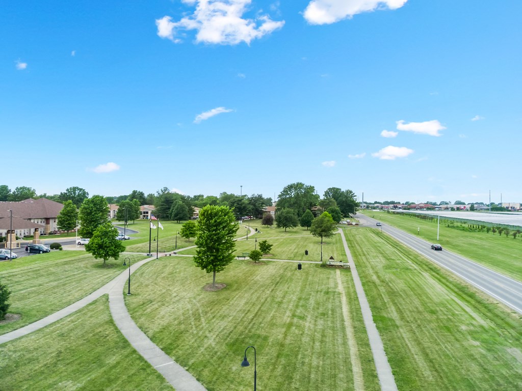 an aerial view of a grassy field next to a highway