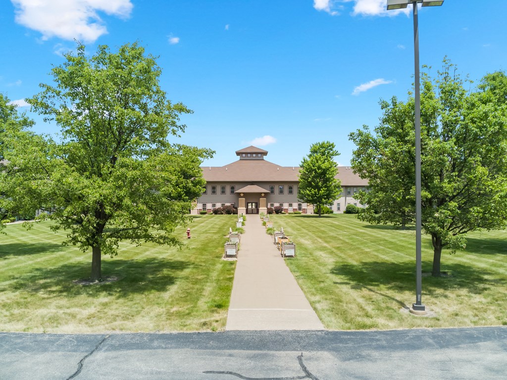 a view of the front of a building with trees and a sidewalk