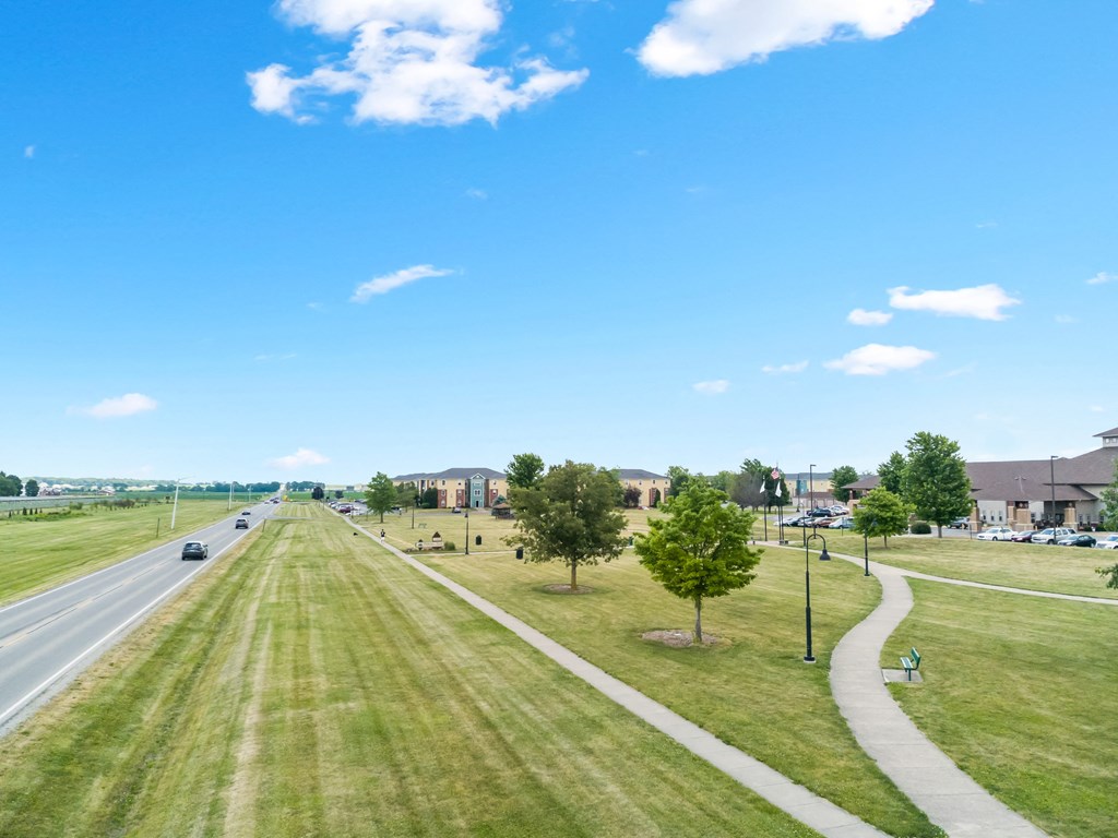 a city street with houses and trees on the side of a highway