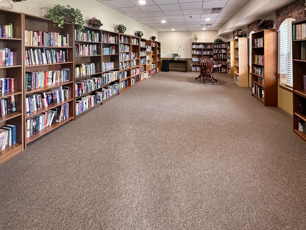 a library with shelves of books and a carpeted floor