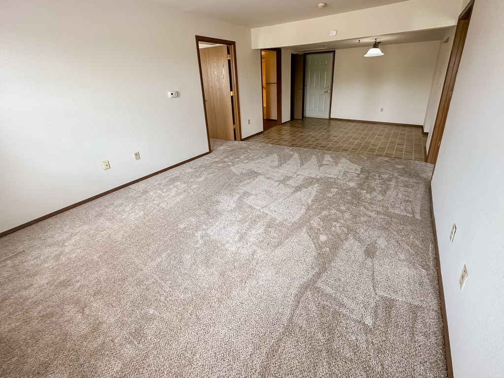 the living room and dining room of an empty apartment
