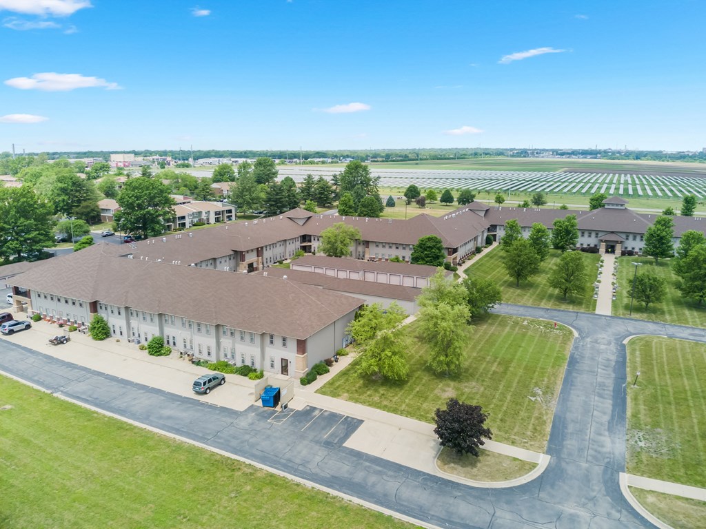 an aerial view of a building with a field in the background