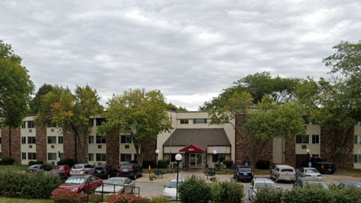 A parking lot with cars and a building in the background.