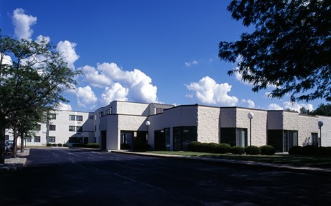 A white building with a parking lot in front.