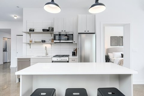 A modern kitchen with white cabinets and appliances.