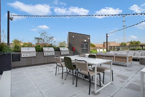 A patio with a table and chairs and a string of lights.