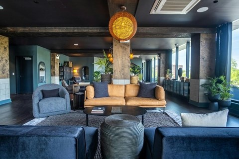 A modern living room with a large circular light fixture and a variety of seating options.