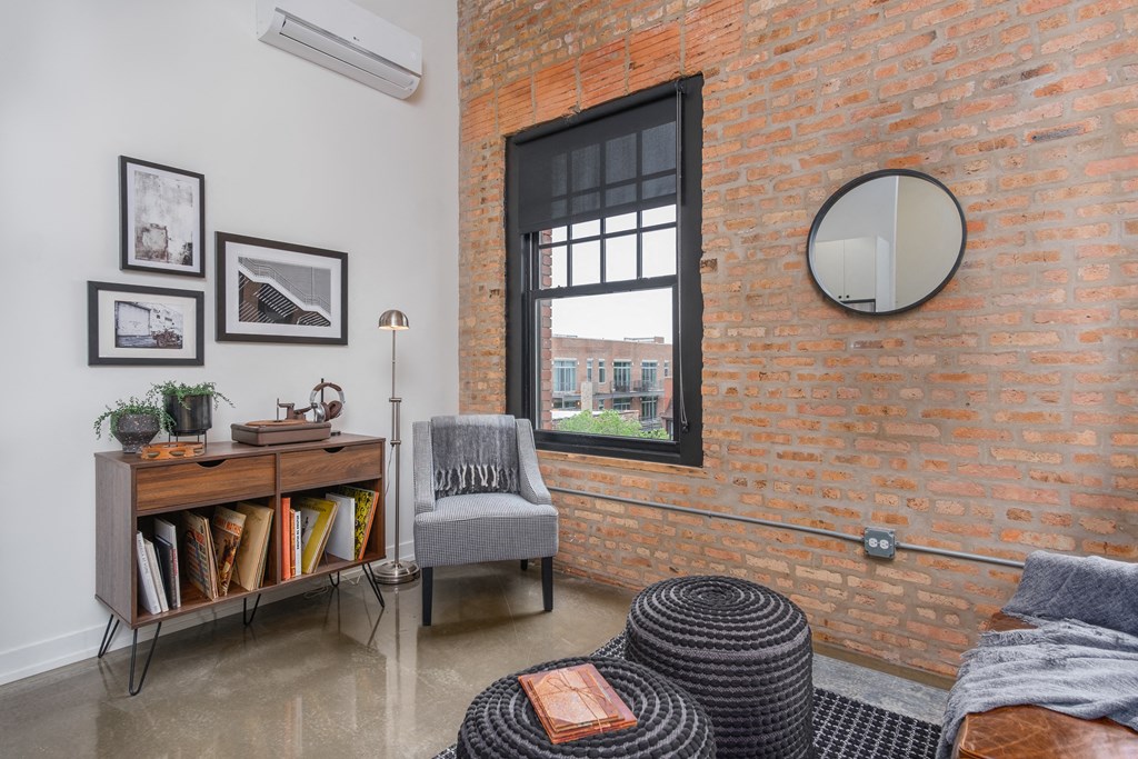 a living room with a brick wall and a window