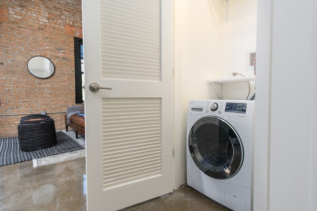 a white door with a washing machine in a laundry room