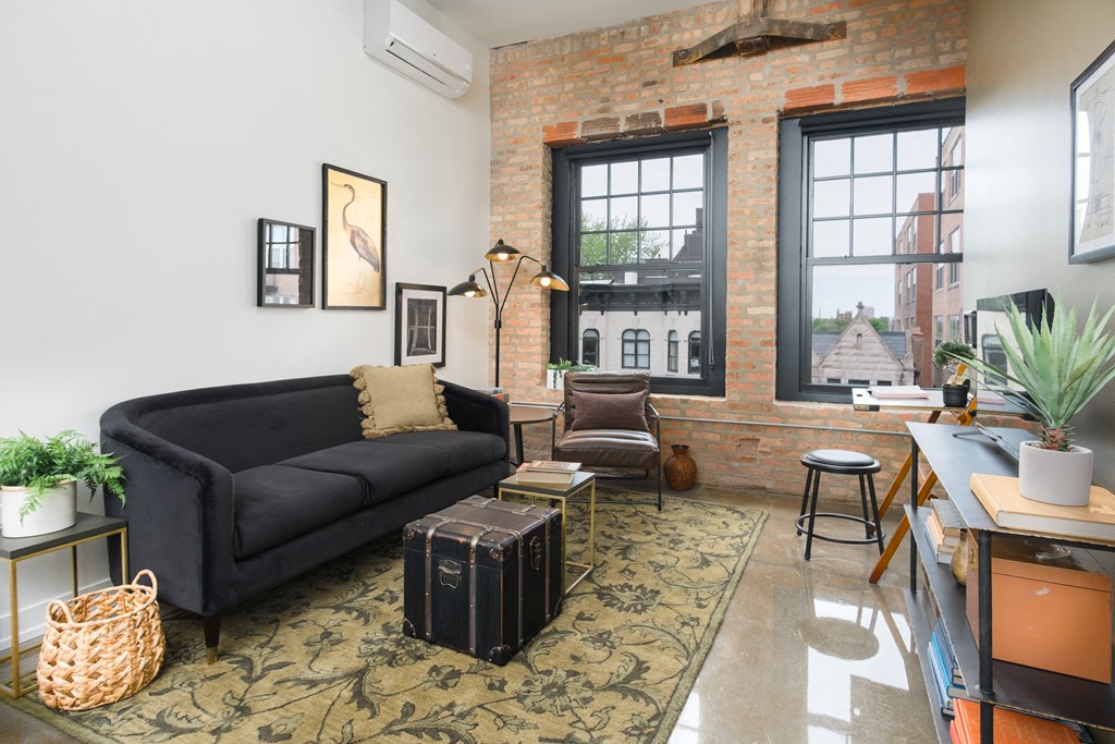 a living room with a black couch and a large window