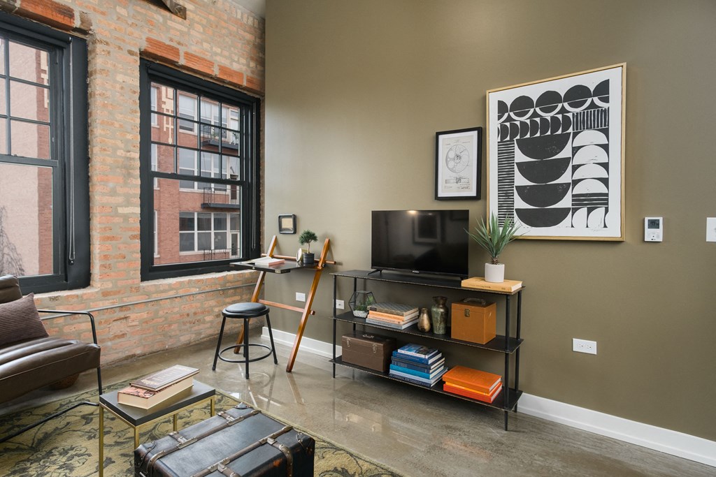 a living room with a television and a brick wall
