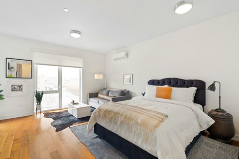 A bedroom with a large bed and a window.