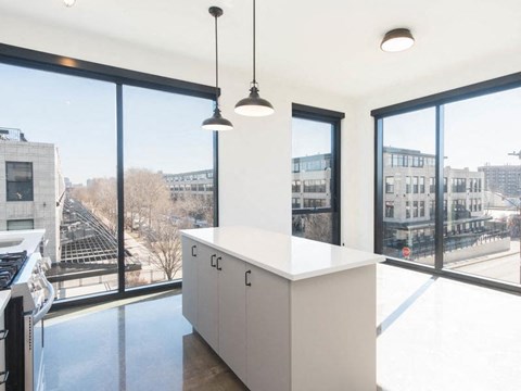 a kitchen with a large window and a white counter top