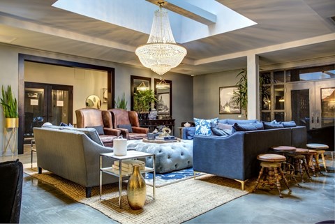A modern living room with a blue sofa and a chandelier.