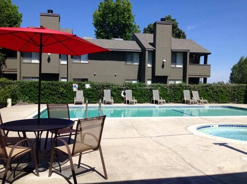 our apartments have a pool and a patio with chairs and umbrella