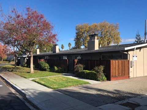 a house with a wooden fence and a sidewalk