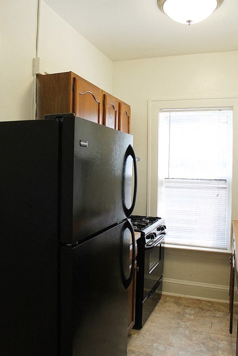 a kitchen with a refrigerator and a stove and a window