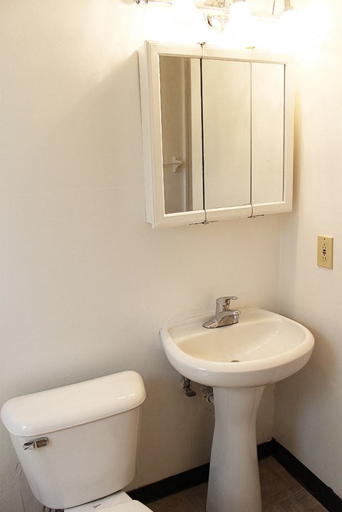 A white toilet and sink in a bathroom.