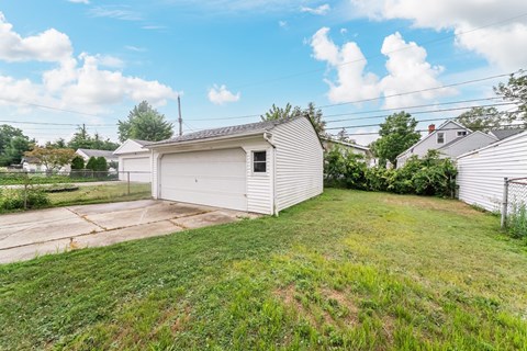 A white garage with a green lawn in front.
