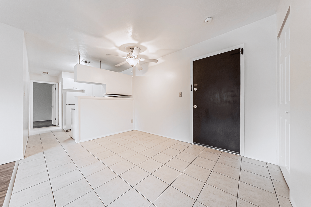 A room with a black door and a ceiling fan.