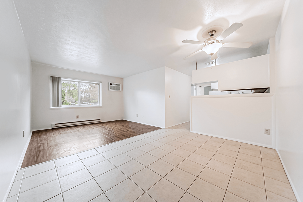Empty room with a ceiling fan and tiled floor.