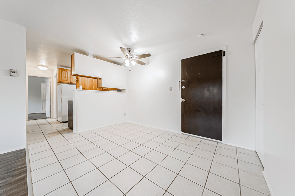 A room with a ceiling fan and a door.