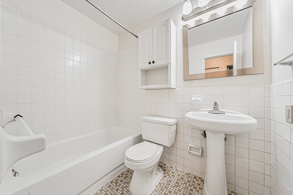 A white bathroom with a toilet, sink, and bathtub.