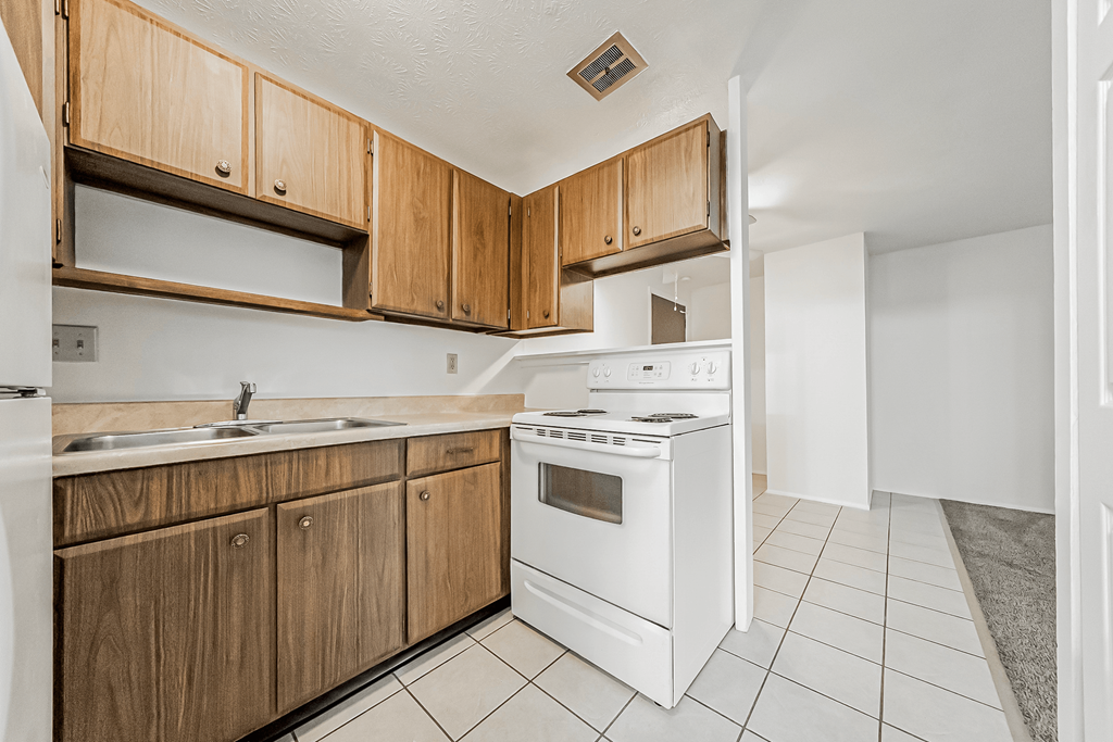 A kitchen with wooden cabinets and white appliances.