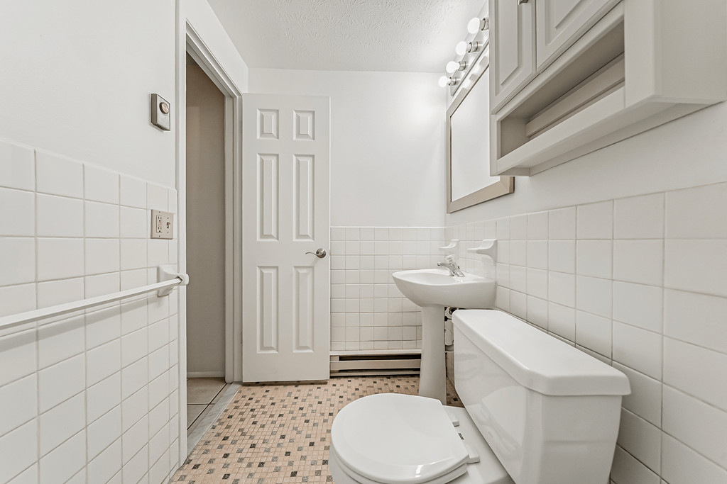 A white bathroom with a toilet, sink, and bathtub.