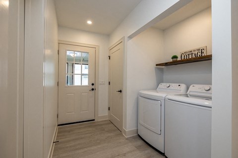 a washer and dryer in a laundry room with a white door