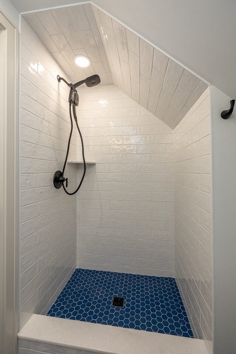 a bathroom with a shower and a blue tile floor