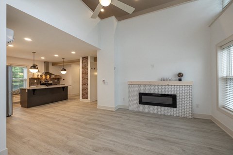 a living room with a fireplace and a kitchen