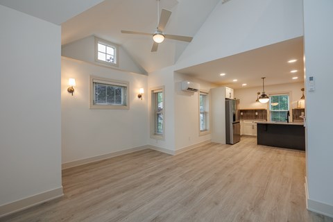 A spacious room with wooden flooring and a ceiling fan.