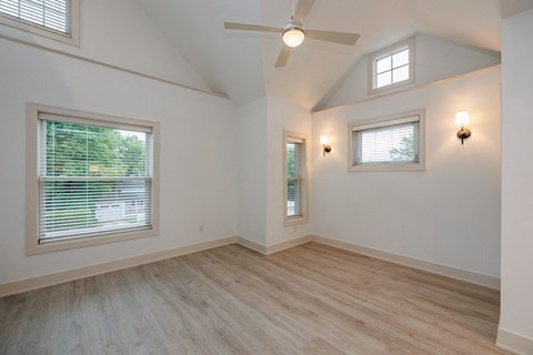 an empty living room with a ceiling fan and a window